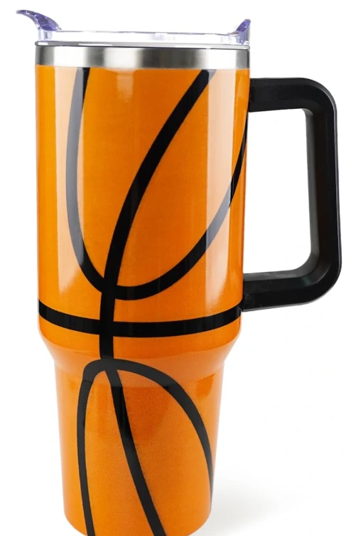 Stainless Steel Basketball Tumbler with handle and lid next to a basketball on a table.