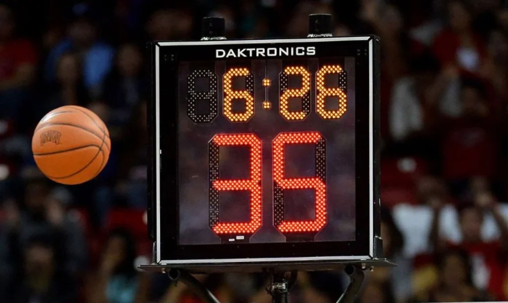 Close-up of an illuminated NBA shot clock showing 35 seconds above a basketball hoop during a professional game.